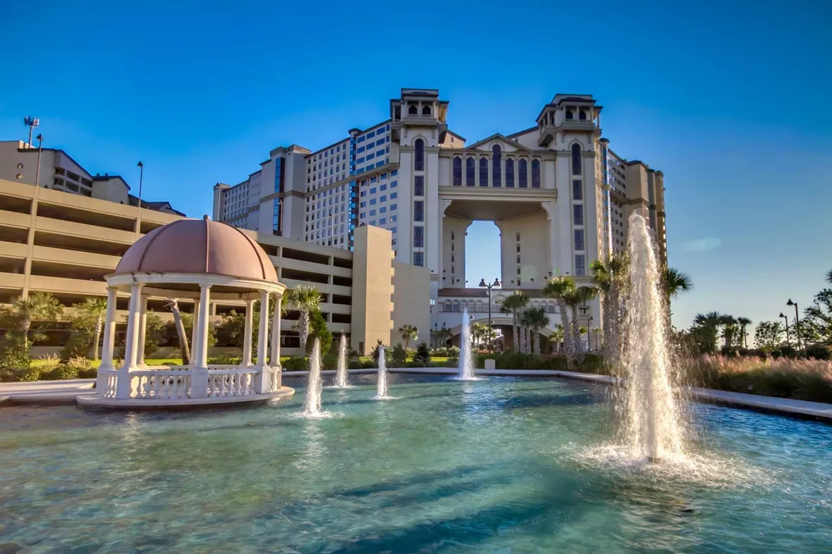 A tranquil garden scene featuring a fountain, a gazebo, and an elegant building backdrop, perfect for post-game relaxation or group gatherings. The atmosphere is serene and inviting.