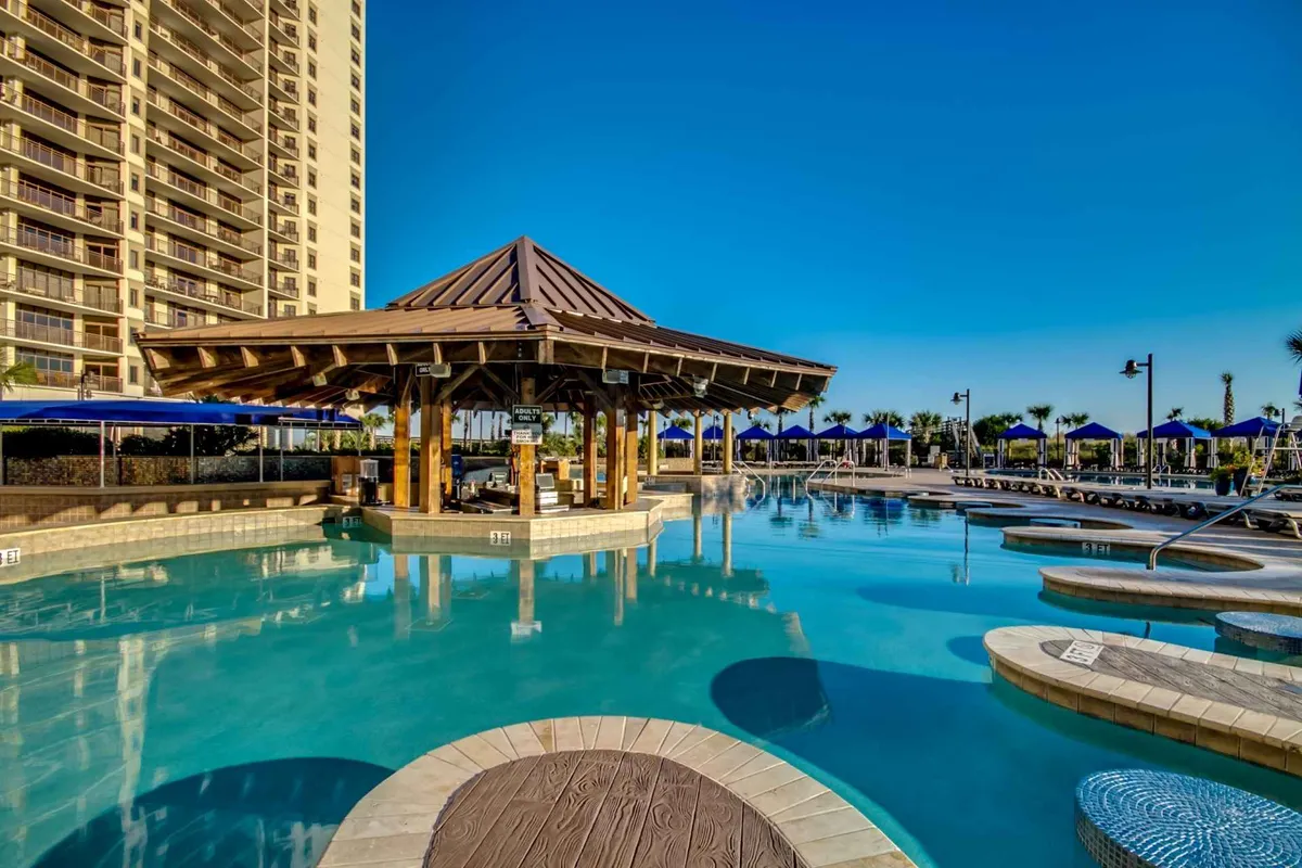 This scene focuses on a sparkling pool surrounded by cabanas, blue umbrellas, and palm trees. The tranquil setting features lounge chairs and shaded spots for relaxation, capturing both the social and peaceful aspects of resort living.
